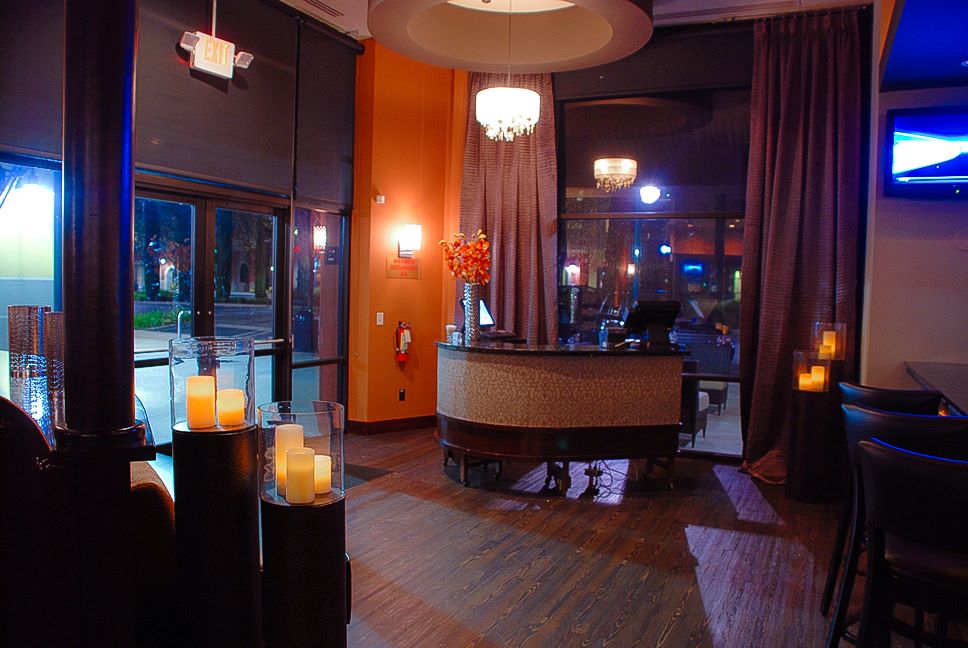Interior entranceway dimly lit with a checkin desk and candles on pedestals